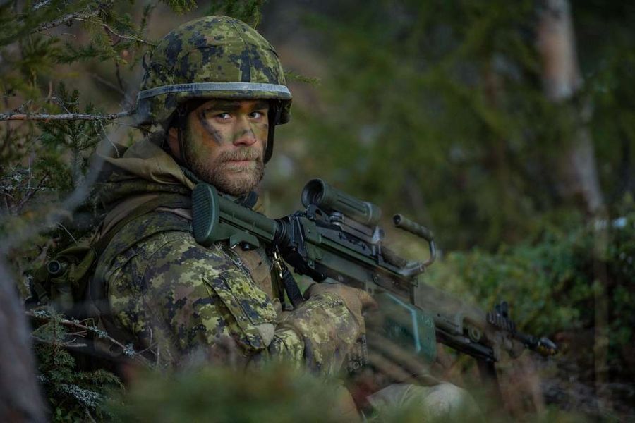 Canadian armed forces soldier holding his rifle in the forest